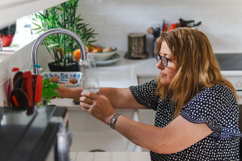 Un verre d’eau rempli au robinet de la cuisine