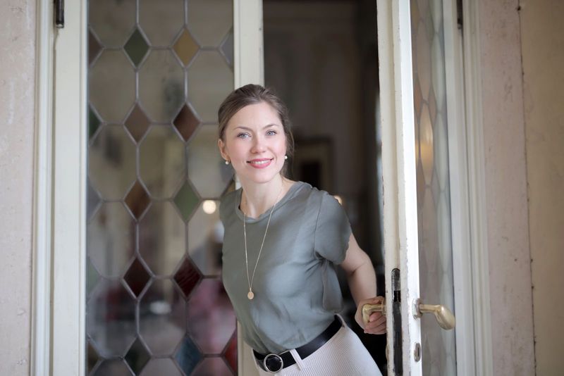 Une jeune femme souriante, prête à sortir de chez elle
