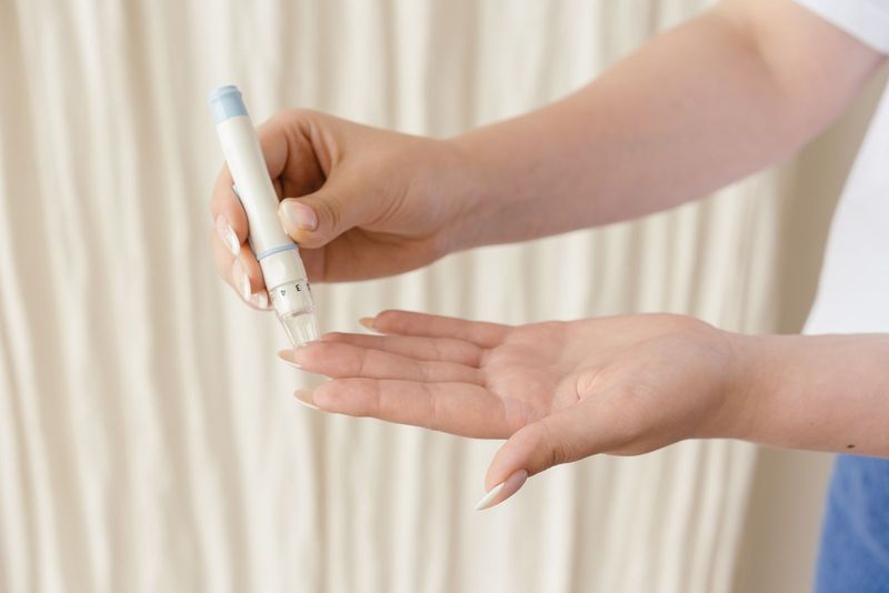 Des mains utilisent un lecteur de glycémie sur une table