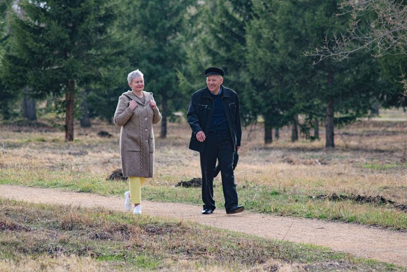 Un couple marche côte à côte dans une allée de parc