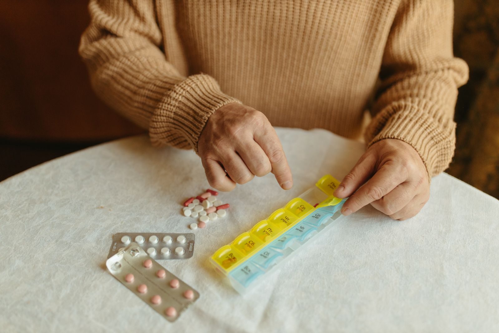 Une personne prépare ses prises de la semaine dans un pilulier