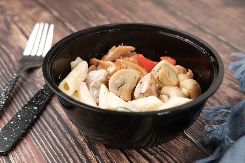 Un plat de pâtes aux légumes servi sur une table en bois
