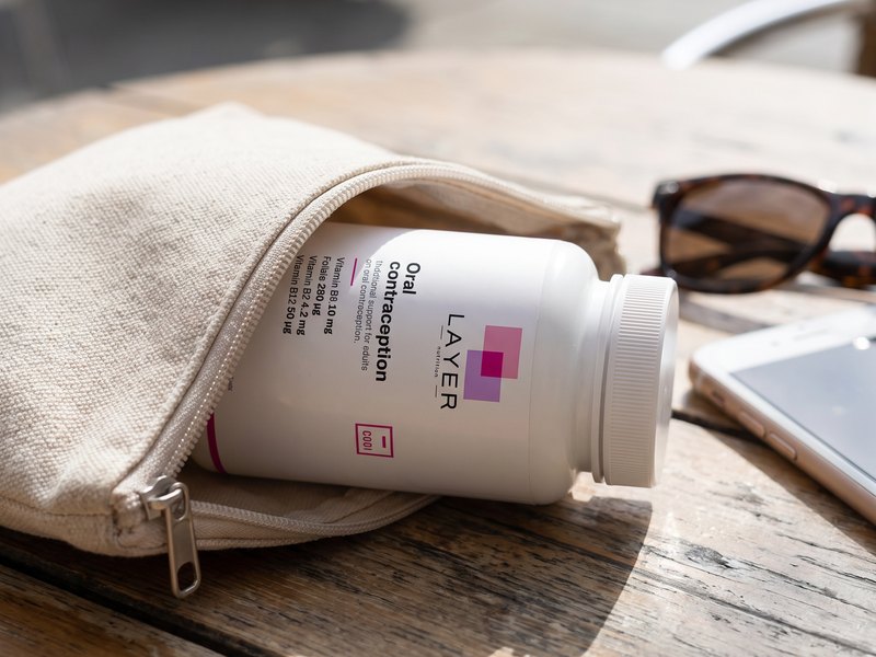 The Layer Nutrition Contraception bottle slipped into a pouch, ready to take along