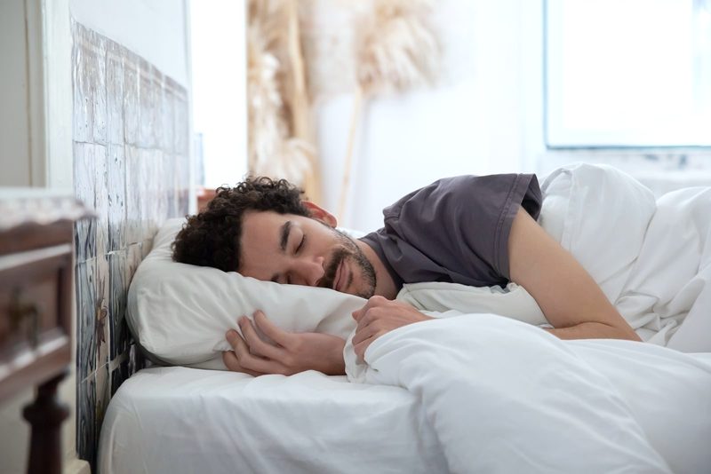 Man sleeping peacefully in a white bed