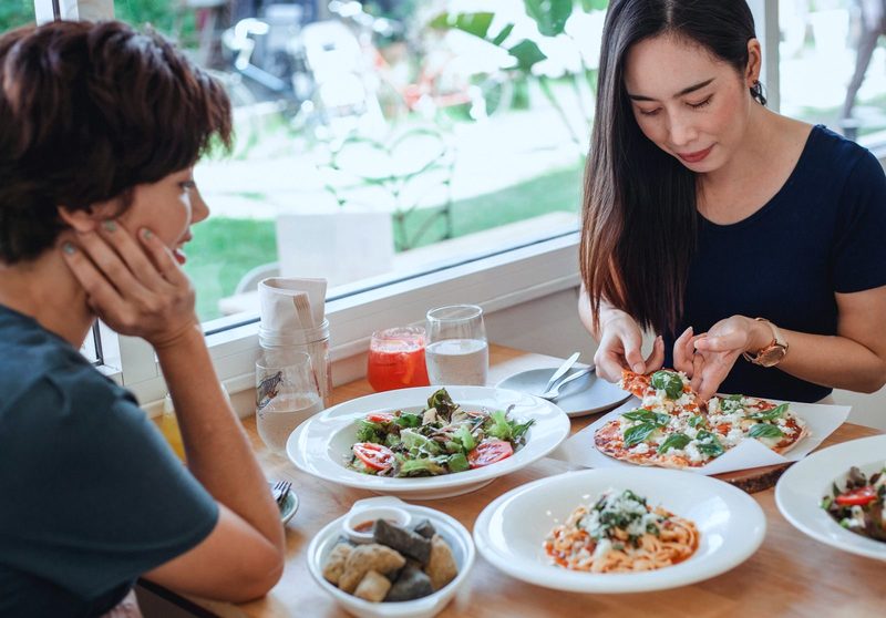 Two women sharing lunch by a window